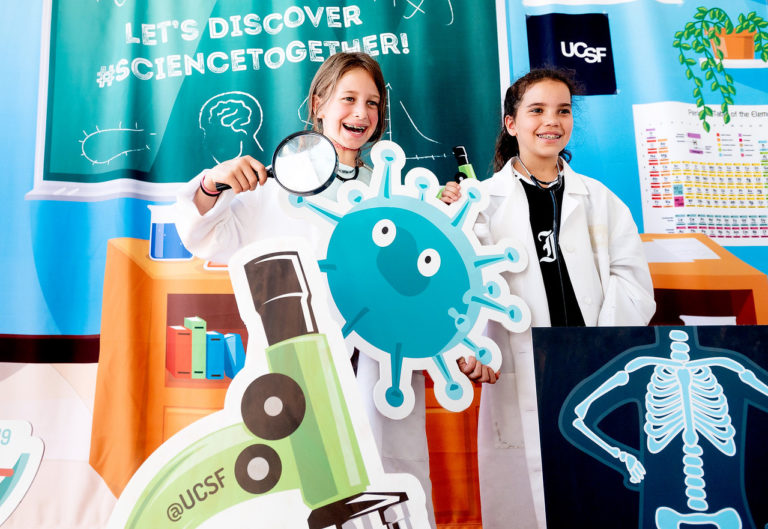 Students hold up images for Let's Discovery Science Together "cellfie" booth