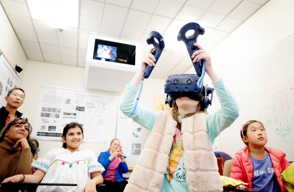 Girl tries virtual reality headset.
